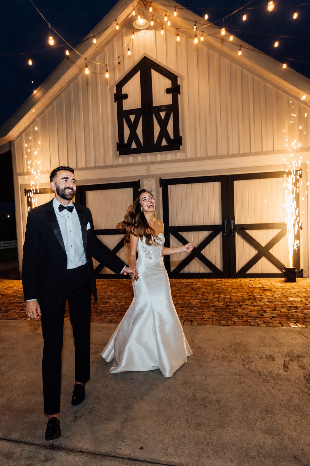 A wedding portrait beside the rustic barn